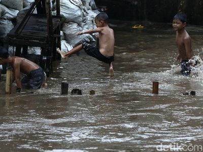 Keceriaan Anak Bukit Duri Bermain di Luapan Sungai Ciliwung