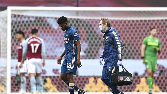 Arsenals Thomas Partey, left, walks after injuring during the English Premier League soccer match between Aston Villa and Arsenal at Villa Park in Birmingham, England, Saturday, Feb. 6, 2021. (Shaun Botterill, Pool via AP)