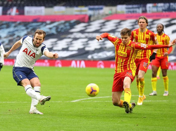 LONDON, ENGLAND - FEBRUARY 07: Harry Kane of Tottenham Hotspur takes a shot whilst under pressure from Conor Townsend of West Bromwich Albion during the Premier League match between Tottenham Hotspur and West Bromwich Albion at Tottenham Hotspur Stadium on February 07, 2021 in London, England. Sporting stadiums around the UK remain under strict restrictions due to the Coronavirus Pandemic as Government social distancing laws prohibit fans inside venues resulting in games being played behind closed doors. (Photo by Julian Finney/Getty Images)