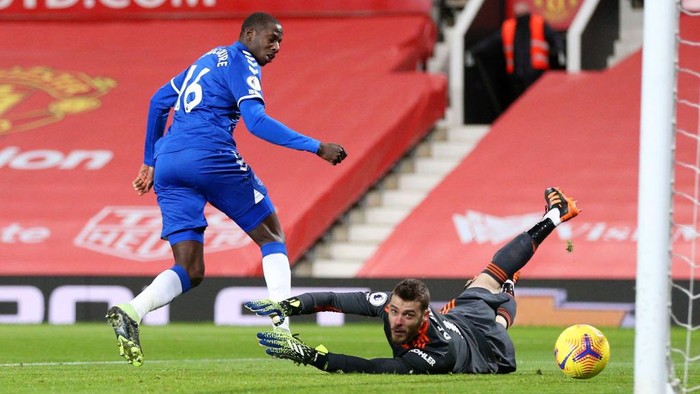 MANCHESTER, ENGLAND - FEBRUARY 06: Abdoulaye Doucoure of Everton scores their teams first goal past David De Gea of Manchester United during the Premier League match between Manchester United and Everton at Old Trafford on February 06, 2021 in Manchester, England. Sporting stadiums around the UK remain under strict restrictions due to the Coronavirus Pandemic as Government social distancing laws prohibit fans inside venues resulting in games being played behind closed doors. (Photo by Alex Pantling/Getty Images)