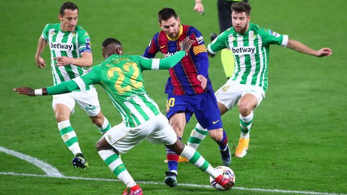 SEVILLE, SPAIN - FEBRUARY 07: Lionel Messi of FC Barcelona is challenged by Andres Guardado, Emerson Royal and Aitor Ruibal of Real Betis during the La Liga Santander match between Real Betis and FC Barcelona at Estadio Benito Villamarin on February 07, 2021 in Seville, Spain. Sporting stadiums around Spain remain under strict restrictions due to the Coronavirus Pandemic as Government social distancing laws prohibit fans inside venues resulting in games being played behind closed doors. (Photo by Fran Santiago/Getty Images)