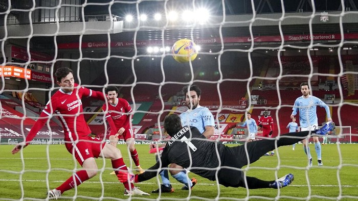Manchester Citys Ilkay Gundogan, center, scores the opening goal past Liverpools goalkeeper Alisson during the English Premier League soccer match between Liverpool and Manchester City at Anfield Stadium, Liverpool, England, Sunday, Feb. 7, 2021. (AP photo/Jon Super, Pool)