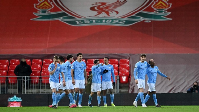LIVERPOOL, ENGLAND - FEBRUARY 07: Raheem Sterling (R) of Manchester City is congratulated by John Stones after scoring their sides third goal  during the Premier League match between Liverpool and Manchester City at Anfield on February 07, 2021 in Liverpool, England. Sporting stadiums around the UK remain under strict restrictions due to the Coronavirus Pandemic as Government social distancing laws prohibit fans inside venues resulting in games being played behind closed doors. (Photo by Laurence Griffiths/Getty Images)