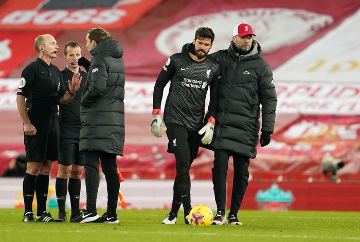 LIVERPOOL, ENGLAND - JANUARY 21: Pepijn Lijnders, assistant manager of Liverpool speaks with match referee, Mike Dean as Jurgen Klopp, Manager of Liverpool walks away with Alisson Becker of Liverpool after talking to match referee, Mike Dean and his officials following the Premier League match between Liverpool and Burnley at Anfield on January 21, 2021 in Liverpool, England. Sporting stadiums around the UK remain under strict restrictions due to the Coronavirus Pandemic as Government social distancing laws prohibit fans inside venues resulting in games being played behind closed doors. (Photo by Jon Super - Pool/Getty Images)