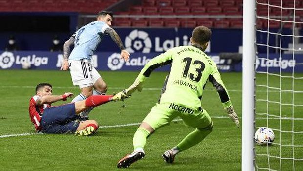 Atletico Madrid's Uruguayan forward Luis Suarez (L) scores a goal during the Spanish league football match between Club Atletico de Madrid and RC Celta de Vigo at the Wanda Metropolitano stadium in Madrid on February 8, 2021. (Photo by PIERRE-PHILIPPE MARCOU / AFP)