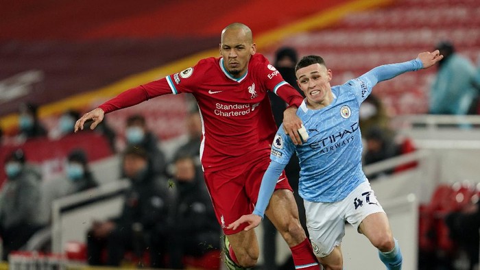 LIVERPOOL, ENGLAND - FEBRUARY 07: Fabinho of Liverpool battles for possession with Phil Foden of Manchester City during the Premier League match between Liverpool and Manchester City at Anfield on February 07, 2021 in Liverpool, England. Sporting stadiums around the UK remain under strict restrictions due to the Coronavirus Pandemic as Government social distancing laws prohibit fans inside venues resulting in games being played behind closed doors (Photo by Jon Super - Pool/Getty Images)