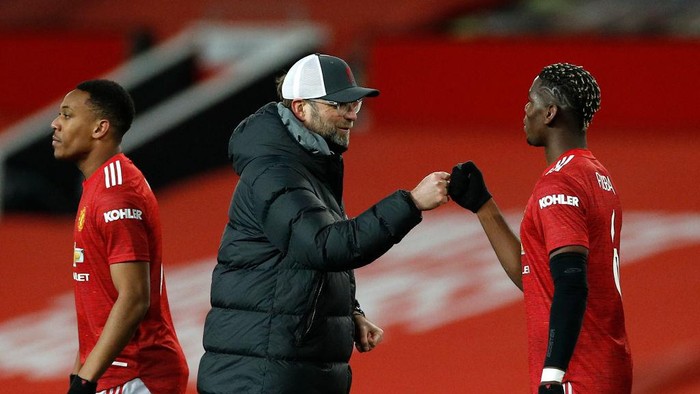 MANCHESTER, ENGLAND - JANUARY 24: Jurgen Klopp, Manager of Liverpool interacts with Paul Pogba of Manchester United following The Emirates FA Cup Fourth Round match between Manchester United and Liverpool at Old Trafford on January 24, 2021 in Manchester, England. Sporting stadiums around the UK remain under strict restrictions due to the Coronavirus Pandemic as Government social distancing laws prohibit fans inside venues resulting in games being played behind closed doors. (Photo by Phil Noble - Pool/Getty Images)