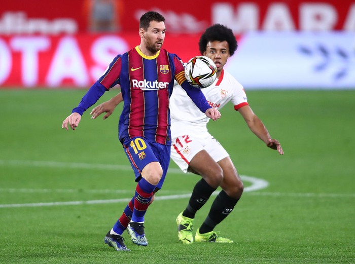 SEVILLE, SPAIN - FEBRUARY 10: Lionel Messi of FC Barcelona battles for possession with Jules Koundé of Sevilla during the Copa del Rey Semi Final First Leg match between Sevilla and FC Barcelona at Estadio Ramon Sanchez Pizjuan on February 10, 2021 in Seville, Spain. Sporting stadiums around Spain remain under strict restrictions due to the Coronavirus Pandemic as Government social distancing laws prohibit fans inside venues resulting in games being played behind closed doors. (Photo by Fran Santiago/Getty Images)