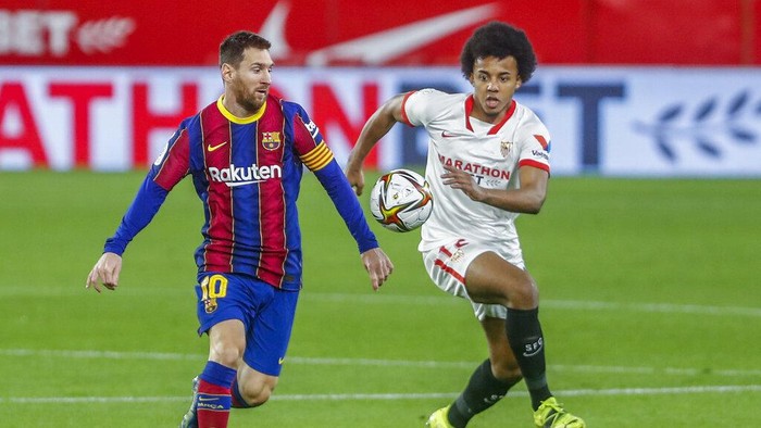Barcelonas Lionel Messi, left, vies for the ball with Sevillas Jules Kounde during a Spanish Copa del Rey semifinal soccer match between Sevilla and FC Barcelona at Ramon Sanchez Pizjuan stadium in Seville , Spain, Wednesday, Feb. 10, 2021. (AP Photo/Angel Fernandez)
