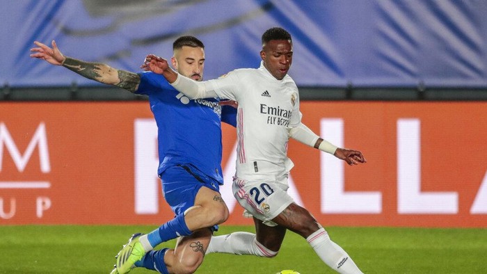 Real Madrids Vinicius Junior, right, fights for the ball with Getafes Erick Cabaco during the Spanish La Liga soccer match between Real Madrid and Getafe at Alfredo di Stefano stadium in Madrid, Spain, Tuesday, Feb. 9, 2021. (AP Photo/Bernat Armangue)