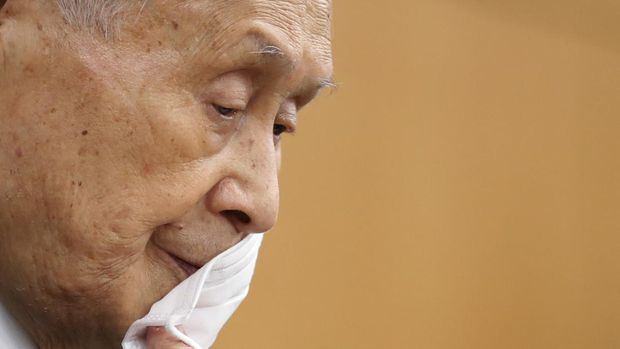 Yoshiro Mori, the president of the Tokyo Olympic organizing committee, takes off his protective face mask as he attends a news conference in Tokyo Thursday, Feb. 4, 2021. (Kim Kyung-hoon/Pool Photo via AP)