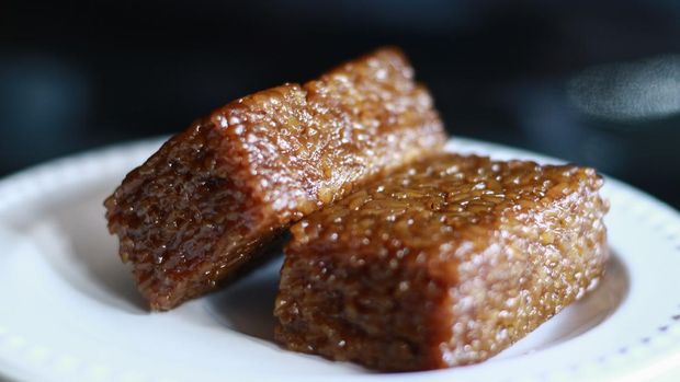 Wajik on black background.  Wajik is traditional snack made with steamed glutinous (sticky) rice and further cooked in palm sugar, coconut milk, and pandan leaves.