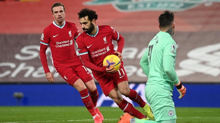 LIVERPOOL, ENGLAND - FEBRUARY 07: Mohamed Salah of Liverpool is congratulated by team mate Jordan Henderson as he collects the ball after scoring their sides first goal from the penalty spot during the Premier League match between Liverpool and Manchester City at Anfield on February 07, 2021 in Liverpool, England. Sporting stadiums around the UK remain under strict restrictions due to the Coronavirus Pandemic as Government social distancing laws prohibit fans inside venues resulting in games being played behind closed doors. (Photo by Laurence Griffiths/Getty Images)
