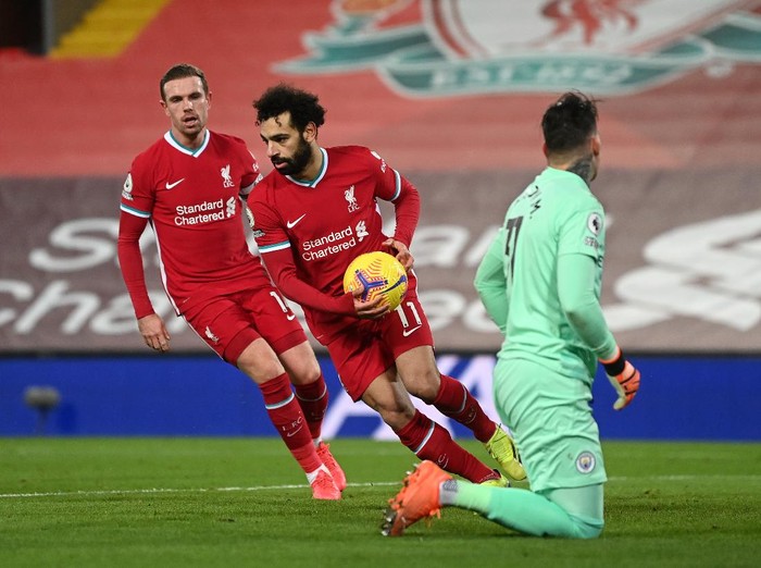 LIVERPOOL, ENGLAND - FEBRUARY 07: Mohamed Salah of Liverpool is congratulated by team mate Jordan Henderson as he collects the ball after scoring their sides first goal from the penalty spot during the Premier League match between Liverpool and Manchester City at Anfield on February 07, 2021 in Liverpool, England. Sporting stadiums around the UK remain under strict restrictions due to the Coronavirus Pandemic as Government social distancing laws prohibit fans inside venues resulting in games being played behind closed doors. (Photo by Laurence Griffiths/Getty Images)