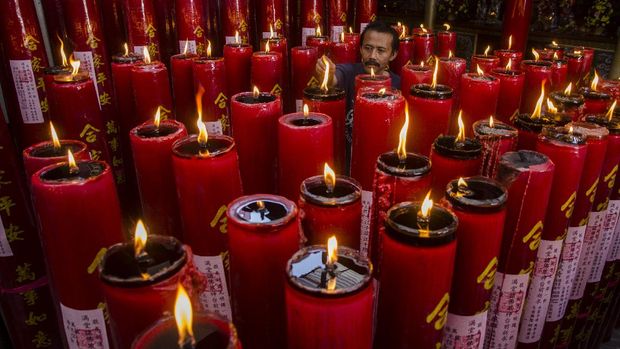 Pengurus Vihara menyalakan lilin doa Tahun Baru Imlek 2572 di Vihara Dharma Ramsi, Bandung, Jawa Barat, Jumat (12/2/2021). Pengurus vihara tersebut membagi waktu untuk beribadah dan menyalakan lilin guna menghindari kerumunan dan menerapkan protokol kesehatan pandemi COVID-19. ANTARA FOTO/Novrian Arbi/foc.