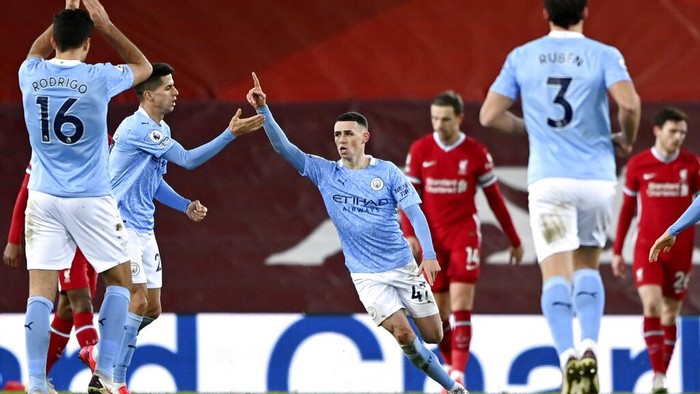Manchester Citys Phil Foden, center, celebrates after scoring his sides fourth goal during the English Premier League soccer match between Liverpool and Manchester City at Anfield Stadium, Liverpool, England, Sunday, Feb. 7, 2021. (Laurence Griffiths/Pool via AP)