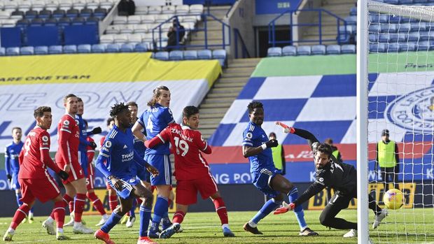 Liverpool's goalkeeper Alisson, right, fails to save the ball as Leicester's James Maddison scores the opening goal during the English Premier League soccer match between Leicester City and Liverpool at the King Power Stadium in Leicester, England, Saturday, Feb. 13, 2021. (Paul Ellis/Pool Photo via AP)