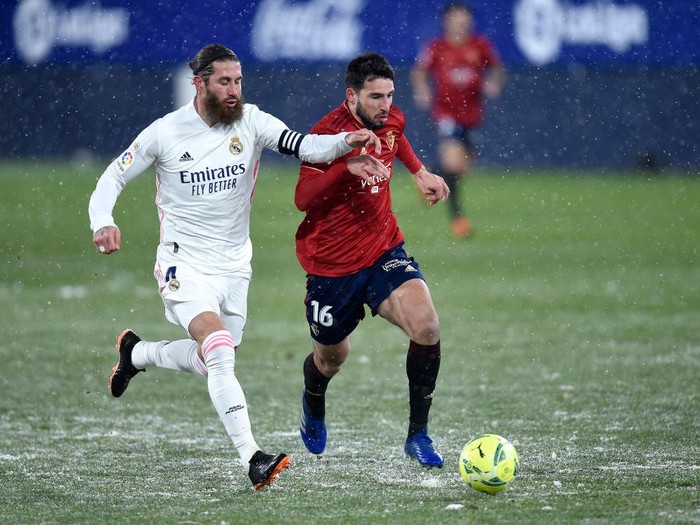 PAMPLONA, SPAIN - JANUARY 09: Jonathan Calleri of Osasuna is challenged by Sergio Ramos of Real Madrid during the La Liga Santander match between C.A. Osasuna and Real Madrid at Estadio El Sadar on January 09, 2021 in Pamplona, Spain. Sporting stadiums around Spain remain under strict restrictions due to the Coronavirus Pandemic as Government social distancing laws prohibit fans inside venues resulting in games being played behind closed doors. (Photo by Juan Manuel Serrano Arce/Getty Images)