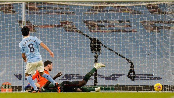 MANCHESTER, ENGLAND - FEBRUARY 13: Ilkay Gundogan of Manchester City scores their sides third goal past Hugo Lloris of Tottenham Hotspur during the Premier League match between Manchester City and Tottenham Hotspur at Etihad Stadium on February 13, 2021 in Manchester, England. Sporting stadiums around the UK remain under strict restrictions due to the Coronavirus Pandemic as Government social distancing laws prohibit fans inside venues resulting in games being played behind closed doors. (Photo by Tim Keeton - Pool/Getty Images)
