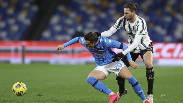 Napoli's Piotr Zielinski, left, competes for the ball with Juventus' Adrien Rabiot, during the Italian Serie A soccer match between Napoli and Juventus at the Diego Armando Maradona stadium in Naples, Italy, Saturday, Feb. 13, 2021. (Alessandro Garofalo/LaPresse via AP)