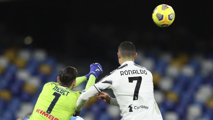 Napolis goalkeeper Alex Meret, left, and Juventus Cristiano Ronaldo, right, in action during the Italian Serie A soccer match between Napoli and Juventus at the Diego Armando Maradona stadium in Naples, Italy, Saturday, Feb. 13, 2021. (Alessandro Garofalo/LaPresse via AP)