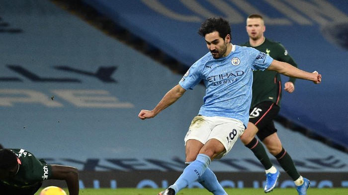 MANCHESTER, ENGLAND - FEBRUARY 13: Ilkay Gundogan of Manchester City scores their sides third goal during the Premier League match between Manchester City and Tottenham Hotspur at Etihad Stadium on February 13, 2021 in Manchester, England. Sporting stadiums around the UK remain under strict restrictions due to the Coronavirus Pandemic as Government social distancing laws prohibit fans inside venues resulting in games being played behind closed doors. (Photo by Rui Vieira - Pool/Getty Images)