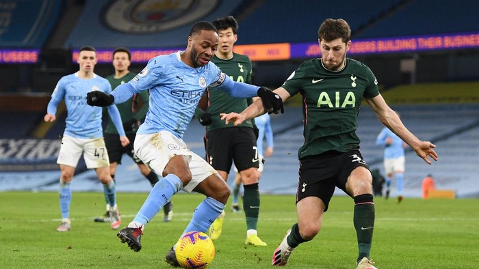 MANCHESTER, ENGLAND - FEBRUARY 13: Raheem Sterling of Manchester City is challenged by Ben Davies of Tottenham Hotspur during the Premier League match between Manchester City and Tottenham Hotspur at Etihad Stadium on February 13, 2021 in Manchester, England. Sporting stadiums around the UK remain under strict restrictions due to the Coronavirus Pandemic as Government social distancing laws prohibit fans inside venues resulting in games being played behind closed doors. (Photo by Shaun Botterill/Getty Images)