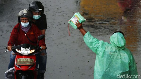Berkah Penjual Mantel di Tengah Guyuran Hujan