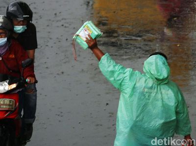 Berkah Penjual Mantel di Tengah Guyuran Hujan