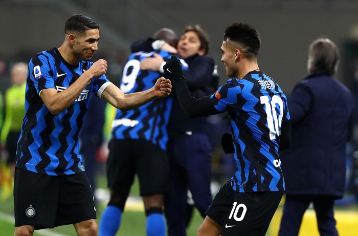 MILAN, ITALY - FEBRUARY 14: Lautaro Martinez of FC Internazionale celebrates with team mate Achraf Hakimi after scoring their side's third goal during the Serie A match between FC Internazionale  and SS Lazio at Stadio Giuseppe Meazza on February 14, 2021 in Milan, Italy. Sporting stadiums around Italy remain under strict restrictions due to the Coronavirus Pandemic as Government social distancing laws prohibit fans inside venues resulting in games being played behind closed doors. (Photo by Marco Luzzani/Getty Images)