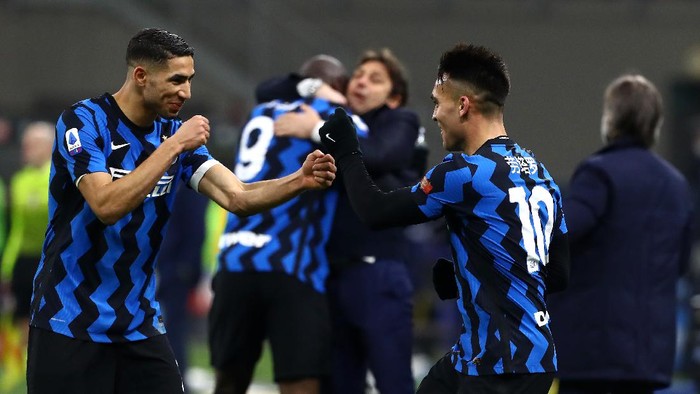 MILAN, ITALY - FEBRUARY 14: Lautaro Martinez of FC Internazionale celebrates with team mate Achraf Hakimi after scoring their sides third goal during the Serie A match between FC Internazionale  and SS Lazio at Stadio Giuseppe Meazza on February 14, 2021 in Milan, Italy. Sporting stadiums around Italy remain under strict restrictions due to the Coronavirus Pandemic as Government social distancing laws prohibit fans inside venues resulting in games being played behind closed doors. (Photo by Marco Luzzani/Getty Images)