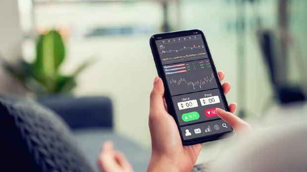 Stock exchange market concept, businesswoman trader looking on smartphone with graphs analysis candle line on sofa in house, diagrams on screen.