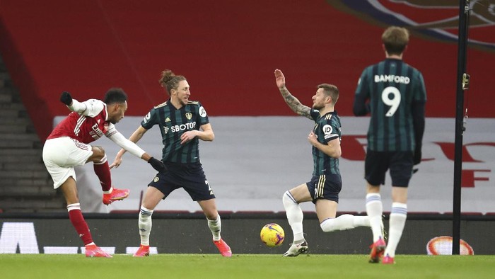 Arsenals Pierre-Emerick Aubameyang, left, scores his sides opening goal during the English Premier League soccer match between Arsenal and Leeds United at the Emirates stadium in London, England, Sunday, Feb. 14, 2021. (Julian Finney/Pool via AP)