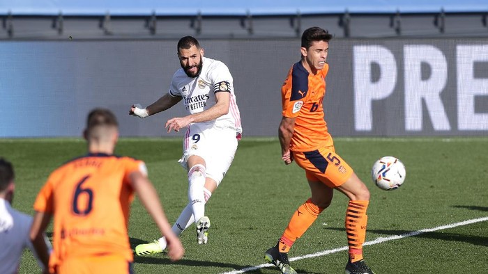 MADRID, SPAIN - FEBRUARY 14: Karim Benzema of Real Madrid scores their sides first goal during the La Liga Santander match between Real Madrid and Valencia CF at Estadio Alfredo Di Stefano on February 14, 2021 in Madrid, Spain. Sporting stadiums around Spain remain under strict restrictions due to the Coronavirus Pandemic as Government social distancing laws prohibit fans inside venues resulting in games being played behind closed doors. (Photo by Gonzalo Arroyo Moreno/Getty Images)
