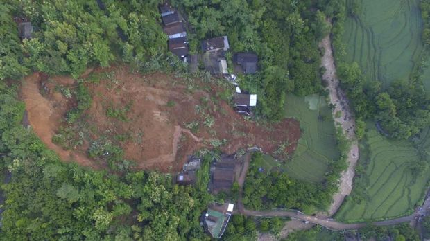 This aerial shot released by the Regional Disaster Mitigation Agency (BPBD) shows a village affected by a landslide in Nganjuk, East Java, Indonesia, Monday, Feb. 15, 2021. Torrential rains triggered a landslide on Indonesia's main island of Java, leaving a number of people killed or missing, as emergency personnel digging with their bare hands and farm tools desperately sought to unearth more victims on Monday, officials said. (Regional Disaster Mitigation Agency via AP)