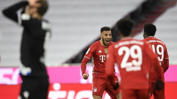 Bayern Munich Bayerns Corentin Tolisso, left, Alphonso Davies, right rear, celebrate the third goal against Arminia during a German Bundesliga soccer match between Bayern Munich and Arminia Bielefeld at the Allianz Arena in Munich, Germany, Monday, Feb. 15, 2021. (AP Photo/Andreas Schaad, Pool)