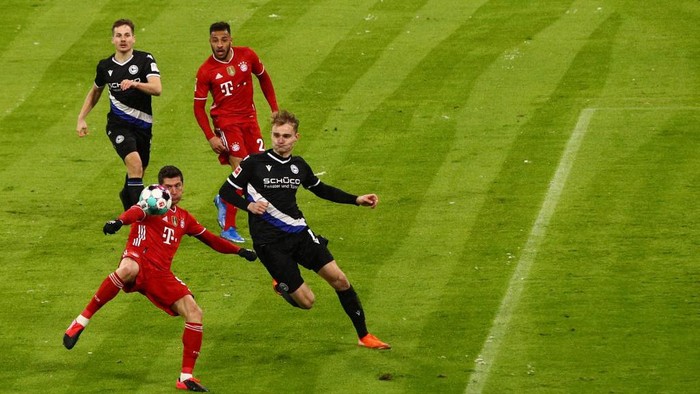 Bayern Munichs Polish forward Robert Lewandowski (L)  scores the 1-2  during the German first division Bundesliga football match FC Bayern Munich v DSC Armenia Bielefeld in Munich, southern Germany on February 15, 2021. (Photo by ADAM PRETTY / various sources / AFP) / DFL REGULATIONS PROHIBIT ANY USE OF PHOTOGRAPHS AS IMAGE SEQUENCES AND/OR QUASI-VIDEO