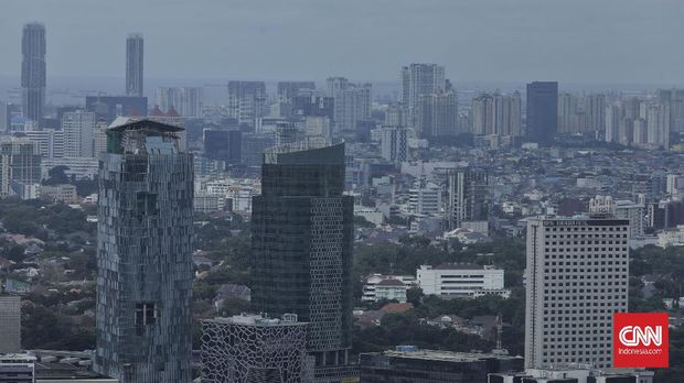 Pekerja melintas di kawasan Jalan Sudirman, Jakarta, Selasa, 16 Februari 2021. CNN Indonesia/Adhi Wicaksono
