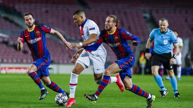 PSG's Kylian Mbappe, center, fights for the ball with Barcelona's Oscar Mingueza during the Champions League round of 16, first leg soccer match between FC Barcelona and Paris Saint-Germain at the Camp Nou stadium in Barcelona, Spain, Tuesday, Feb. 16, 2021. (AP Photo/Joan Monfort)