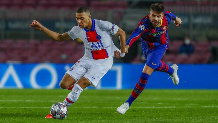 Barcelonas Gerard Pique, right, tries to stop PSGs Kylian Mbappe during the Champions League round of 16, first leg soccer match between FC Barcelona and Paris Saint-Germain at the Camp Nou stadium in Barcelona, Spain, Tuesday, Feb. 16, 2021. (AP Photo/Joan Monfort)
