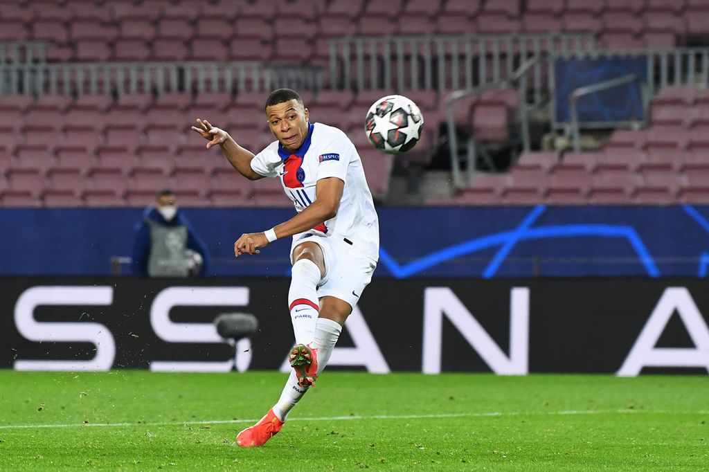 BARCELONA, SPAIN - FEBRUARY 16: Kylian Mbappe of Paris Saint-Germain scores their side's fourth goal during the UEFA Champions League Round of 16 match between FC Barcelona and Paris Saint-Germain at Camp Nou on February 16, 2021 in Barcelona, Spain. Sporting stadiums around Spain remain under strict restrictions due to the Coronavirus Pandemic as Government social distancing laws prohibit fans inside venues resulting in games being played behind closed doors. (Photo by David Ramos/Getty Images)
