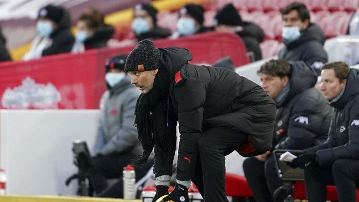 Manchester Citys head coach Pep Guardiola picks up a ball during the English Premier League soccer match between Liverpool and Manchester City at Anfield Stadium, Liverpool, England, Sunday, Feb. 7, 2021. (AP photo/Jon Super, Pool)