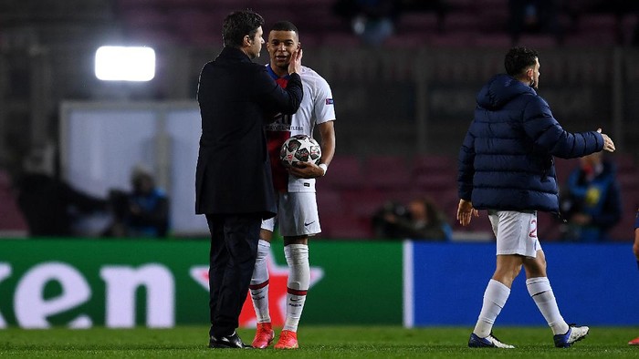 BARCELONA, SPAIN - FEBRUARY 16: Kylian Mbappe of Paris Saint-Germain is congratulated by Mauricio Pochettino, Head Coach of Paris Saint-Germain as he holds the match ball after scoring a hat-trick during the UEFA Champions League Round of 16 match between FC Barcelona and Paris Saint-Germain at Camp Nou on February 16, 2021 in Barcelona, Spain. Sporting stadiums around Spain remain under strict restrictions due to the Coronavirus Pandemic as Government social distancing laws prohibit fans inside venues resulting in games being played behind closed doors. (Photo by David Ramos/Getty Images)