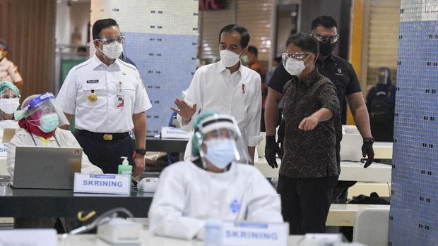 Presiden Joko Widodo (tengah) didampingi Menteri Kesehatan Budi Gunadi Sadikin (kanan) dan Gubernur DKI Jakarta Anies Baswedan meninjau vaksinasi COVID-19 massal bagi pedagang di Pasar Tanah Abang Blok A, Jakarta, Rabu (17/2/2021). Vaksinasi COVID-19 tahap kedua yang diberikan untuk pekerja publik dan lansia itu dimulai dari pedagang Pasar Tanah Abang. ANTARA FOTO/Hafidz Mubarak A/wsj.