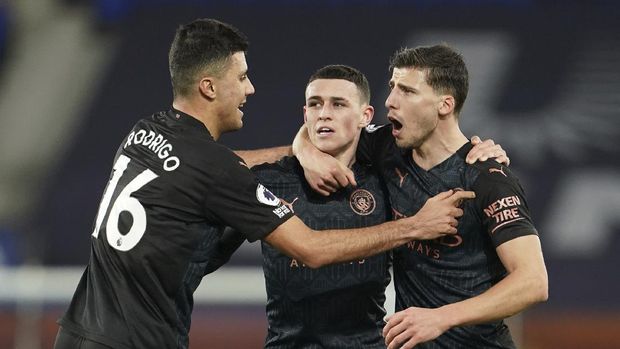 Manchester City's Phil Foden, center, celebrates scoring his side's first goal during the English Premier League soccer match between Everton and Manchester City at Goodison Park stadium, in Liverpool, England, Wednesday, Feb. 17, 2021. (Jon Super/Pool via AP)