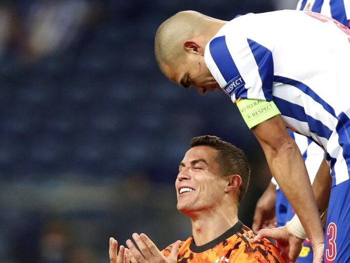Porto's Pepe watches as Juventus' Cristiano Ronaldo gestures on the ground during the Champions League round of 16, first leg, soccer match between FC Porto and Juventus at the Dragao stadium in Porto, Portugal, Wednesday, Feb. 17, 2021. (AP Photo/Luis Vieira)