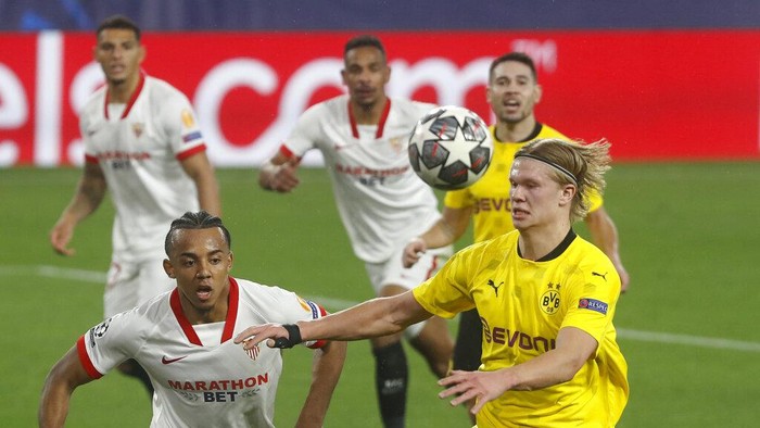 Dortmunds Erling Haaland, right, challenges for the ball with Sevillas Jules Kounde during the Champions League, round of 16, first leg soccer match between Sevilla and Borussia Dortmund at the Ramon Sanchez Pizjuan stadium in Seville, Spain, Wednesday, Feb. 17, 2021. (AP Photo/Angel Fernandez)