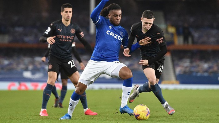 LIVERPOOL, ENGLAND - FEBRUARY 17: Alex Iwobi of Everton battles for possession with Phil Foden of Manchester City during the Premier League match between Everton and Manchester City at Goodison Park on February 17, 2021 in Liverpool, England. Sporting stadiums around the UK remain under strict restrictions due to the Coronavirus Pandemic as Government social distancing laws prohibit fans inside venues resulting in games being played behind closed doors. (Photo by Peter Powell - Pool/Getty Images)