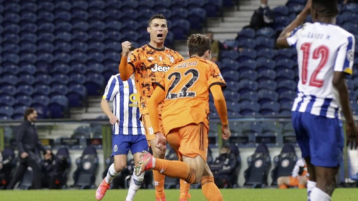 Juventus Cristiano Ronaldo celebrates after teammate Federico Chiesa, center, scored their sides first goal during the Champions League round of 16, first leg, soccer match between FC Porto and Juventus at the Dragao stadium in Porto, Portugal, Wednesday, Feb. 17, 2021. (AP Photo/Luis Vieira)