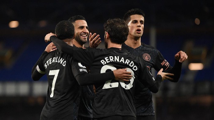 LIVERPOOL, ENGLAND - FEBRUARY 17: Bernardo Silva of Manchester City celebrates with team mates (L - R) Raheem Sterling, Riyad Mahrez, Joao Cancelo after scoring their sides third goal during the Premier League match between Everton and Manchester City at Goodison Park on February 17, 2021 in Liverpool, England. Sporting stadiums around the UK remain under strict restrictions due to the Coronavirus Pandemic as Government social distancing laws prohibit fans inside venues resulting in games being played behind closed doors. (Photo by Michael Regan/Getty Images)
